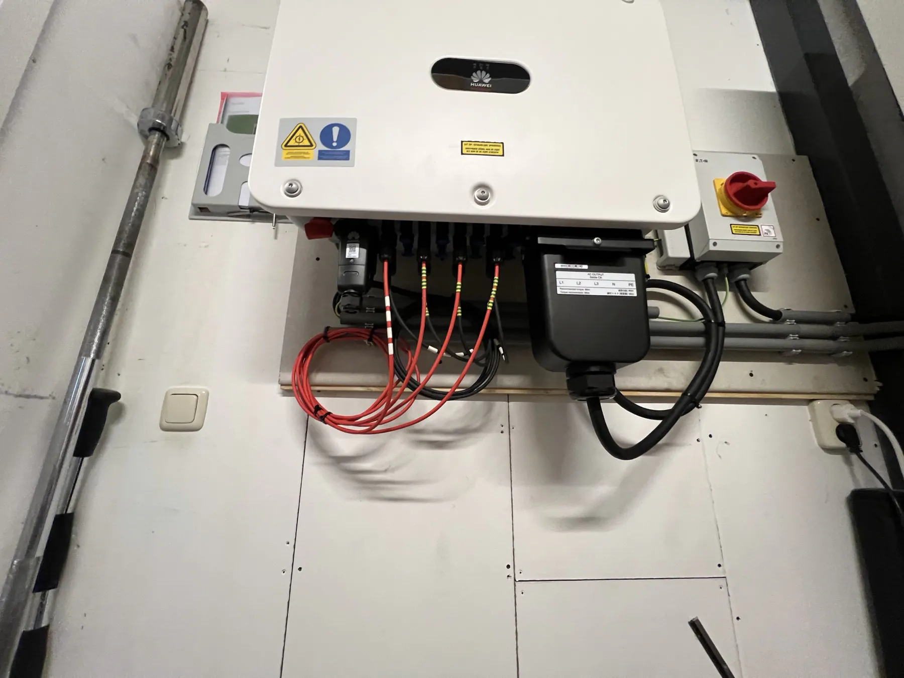 De omvormer met bekabeling tegen de wand binnen