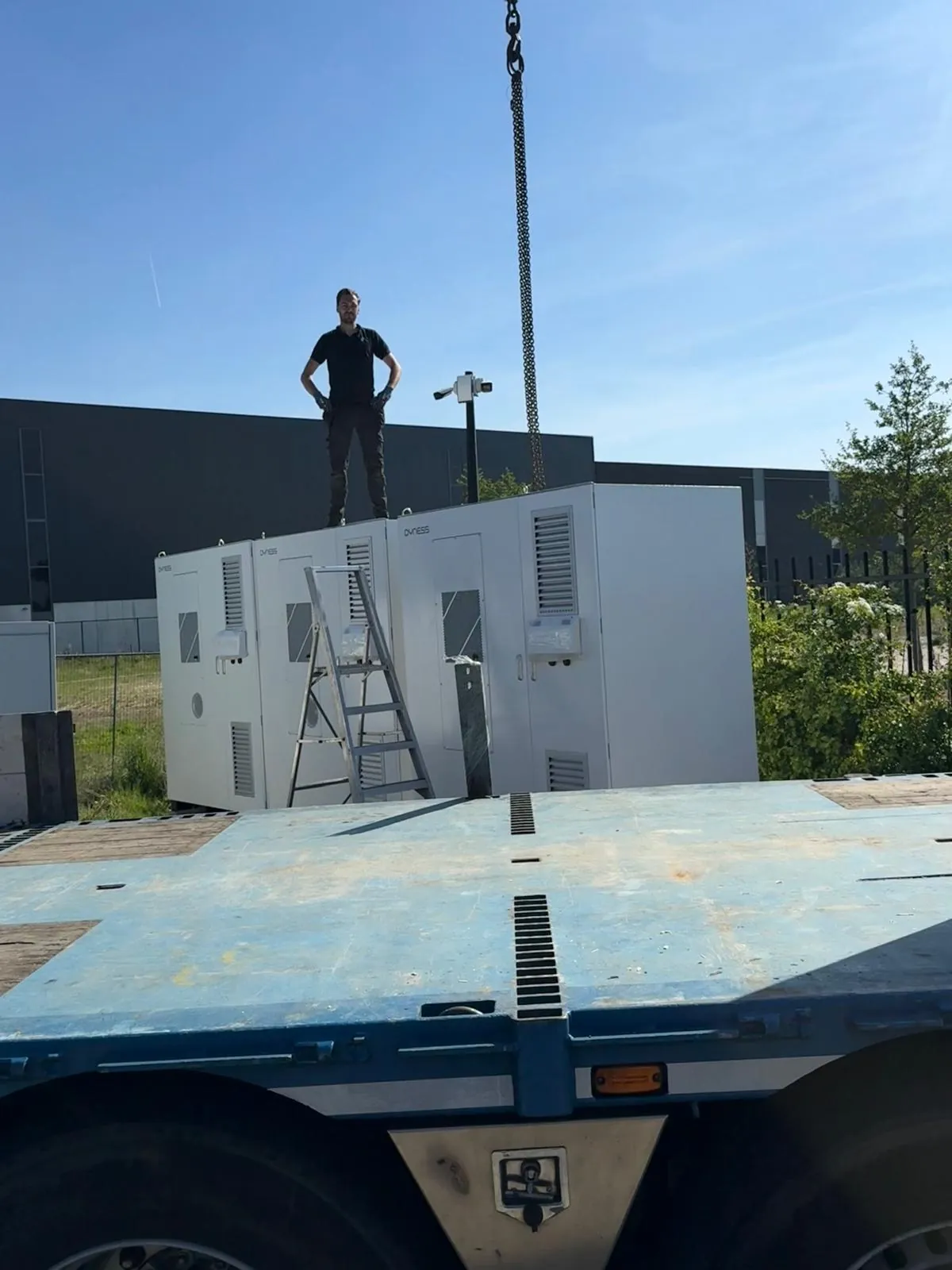 Plaatsing van de energieopslagkasten op locatie, aangevoerd op een dieplader