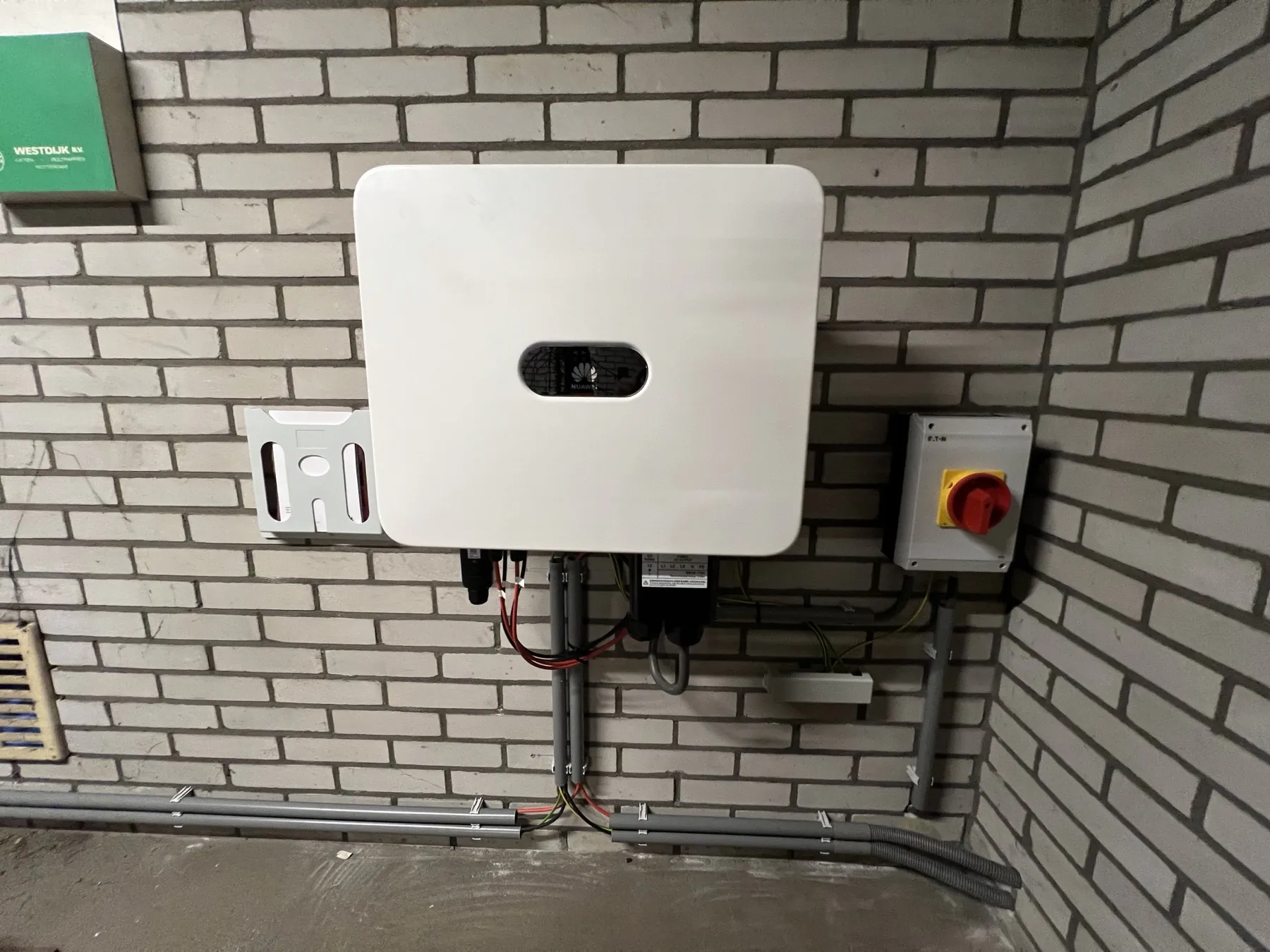 De omvormer tegen de buitenmuur van het gebouw