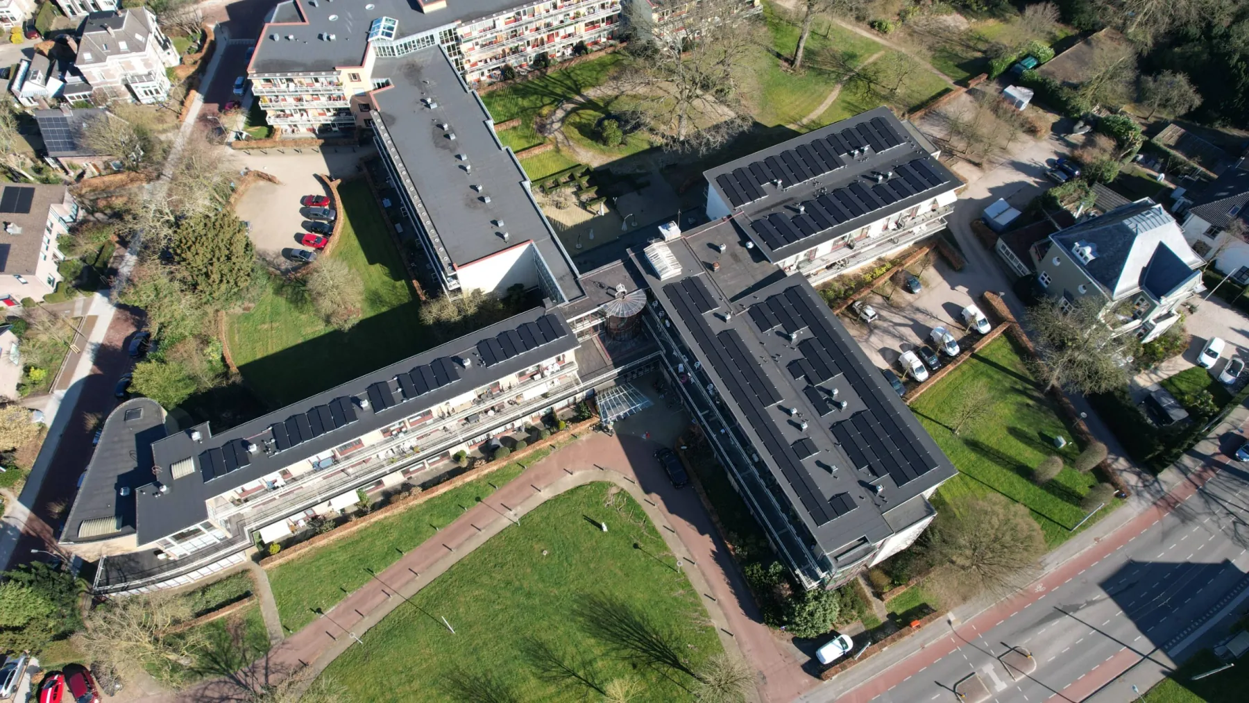 Luchtfoto van het wooncomplex Nieuw-Schoonoord in Velp, met zonnepanelen over de daken van de vleugels