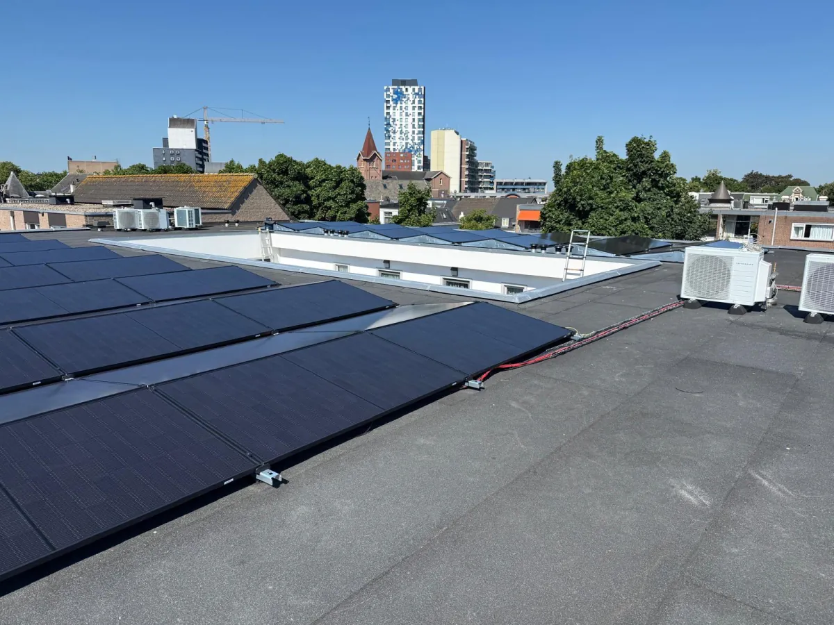 Het langgerekte dakvlak met de panelen, met de stadssilhouet op de achtergrond