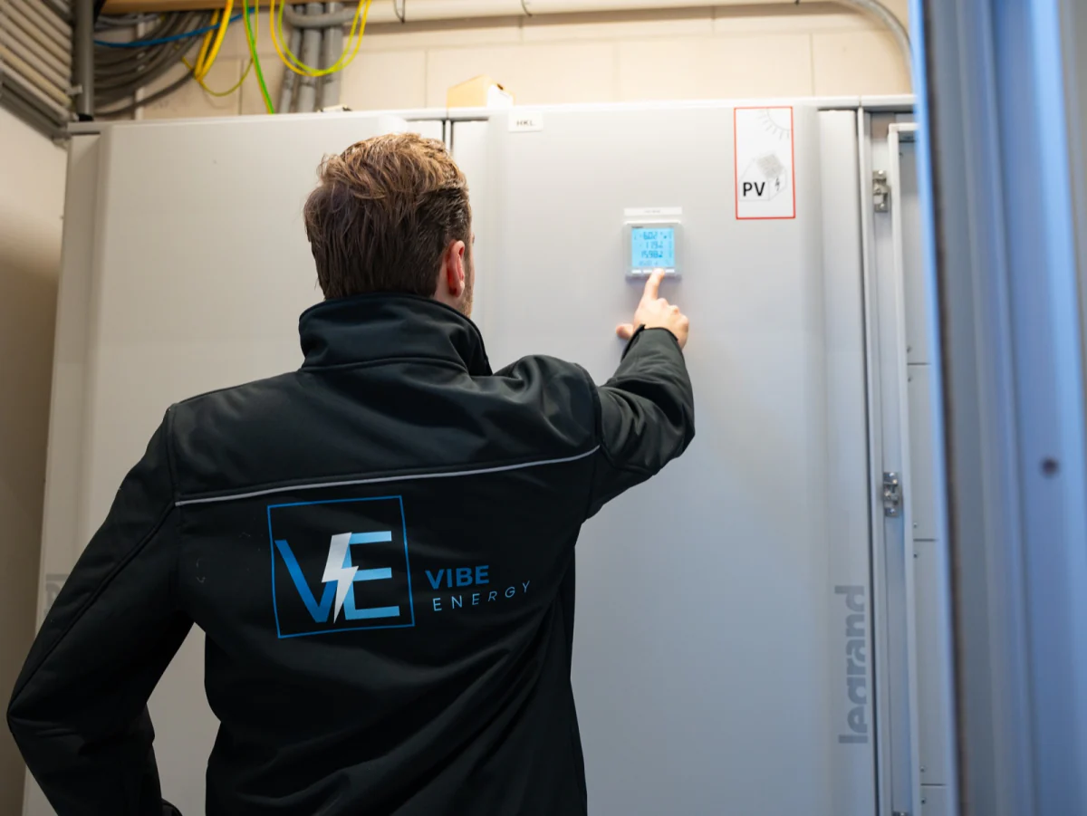 Monteur van Vibe Energy leest op locatie de display van de PV-meting af op een verdeelkast